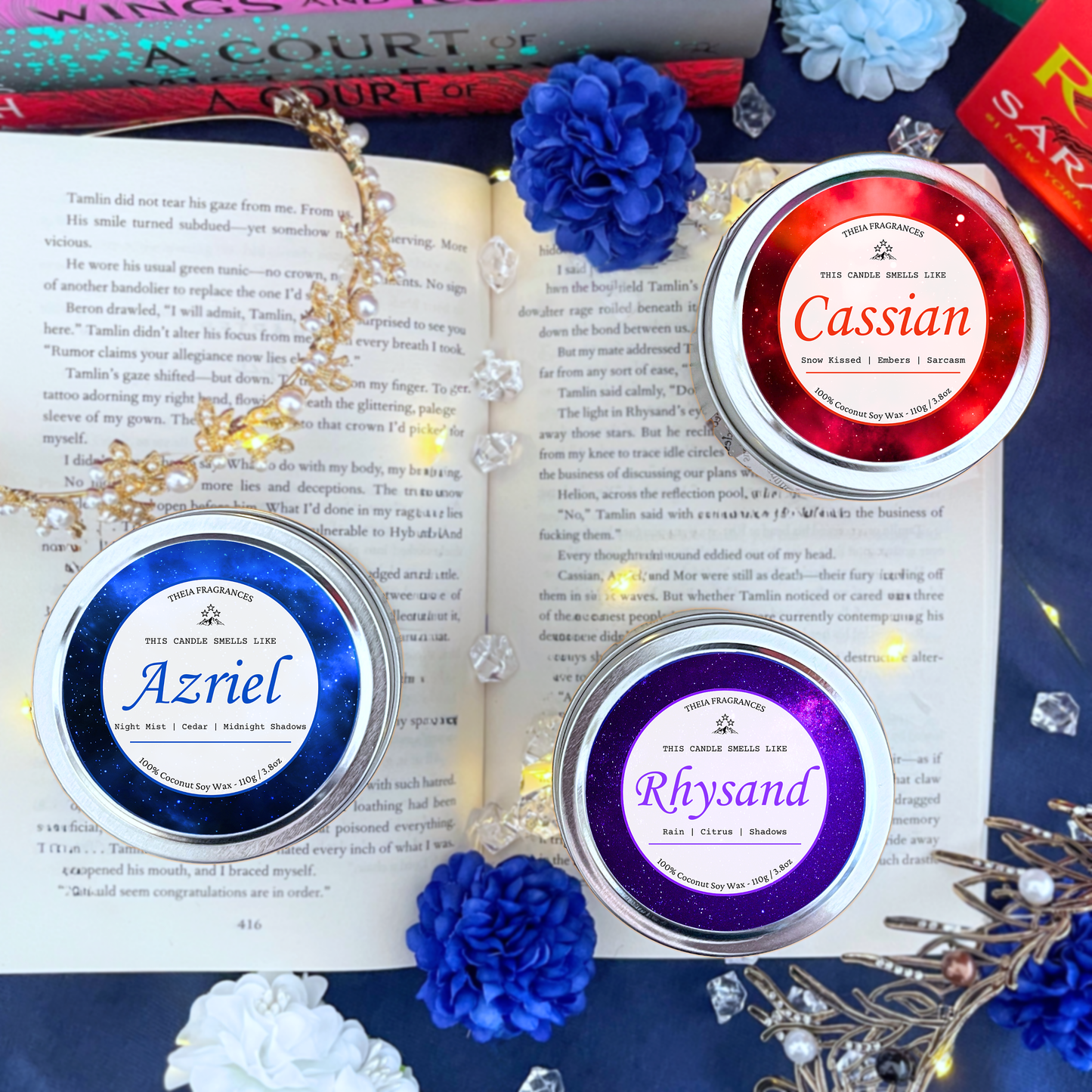 The 'Bat Boys Bundle' made of coconut soy wax by Theia Fragrances provides two sizes - a 215G glass jar with a black lid and a 110G round tin. They are styled on an open book with decorative crystals and a colorful bookshelf background.