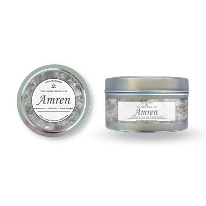 The 'Tiny Ancient One' coconut soy wax candle by Theia Fragrances is demonstrated in the 110G tin candle. The label features a grey galaxy. It is styled on an open book with decorative crystals and flowers.